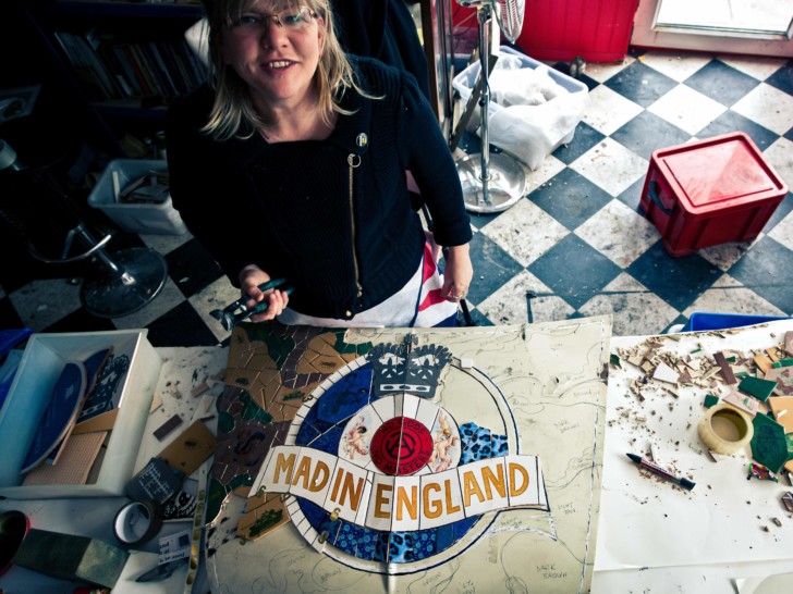Carrie photographed from above making a mosaic that reads 'Mad in England'