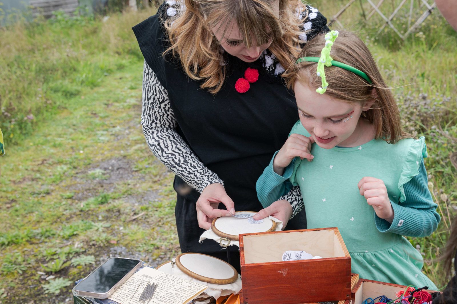 A mother and daughter choose embroidery transfers together.