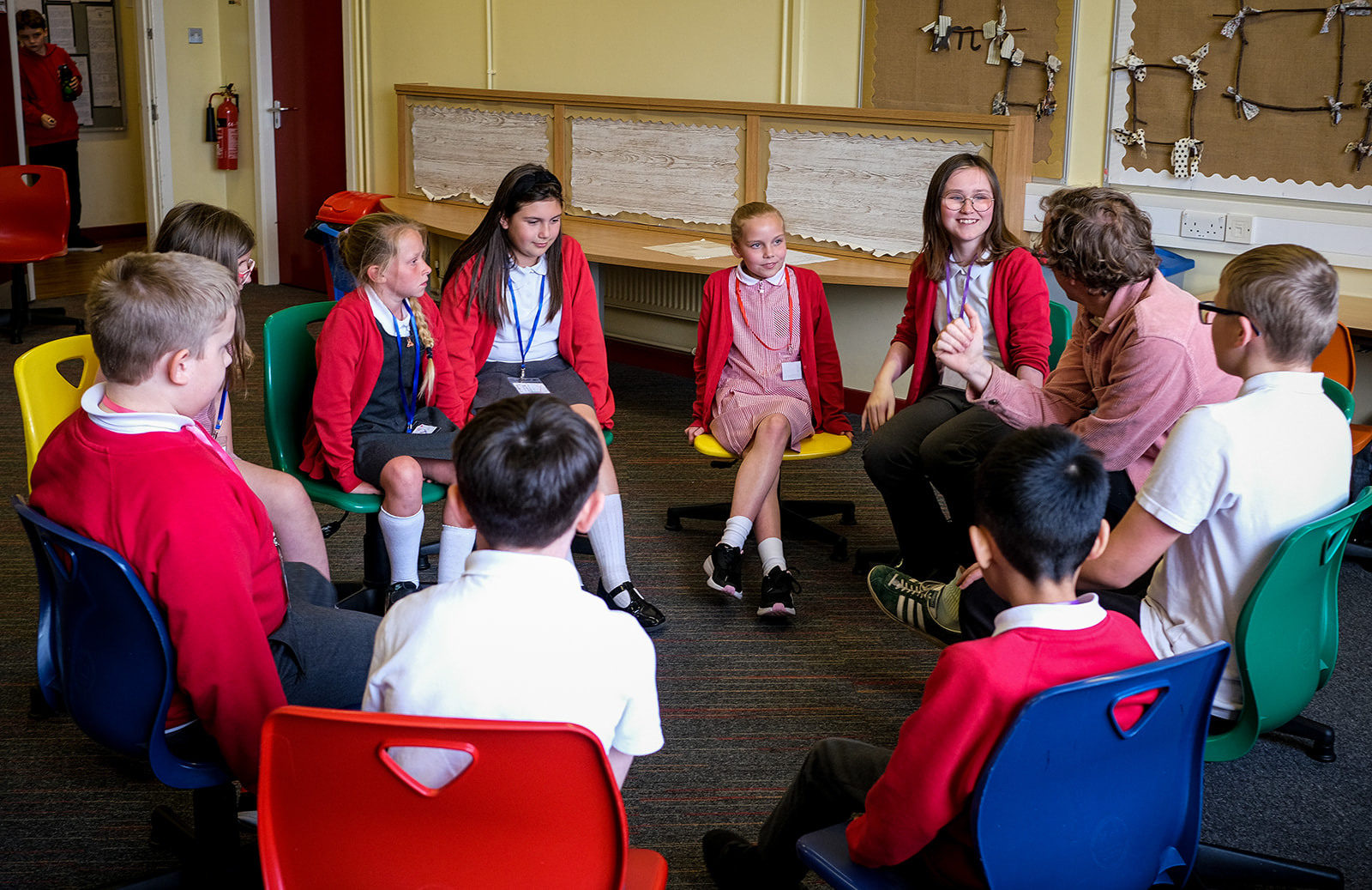 Schoolchildren sat around in a circle talking to Andy.