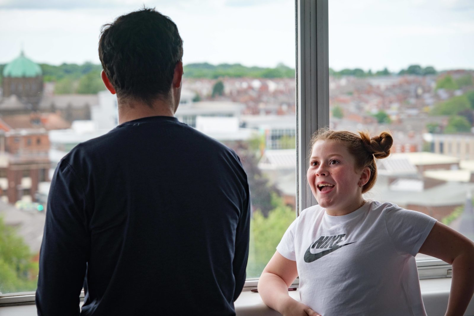 A young girl is smiling talking to a man.