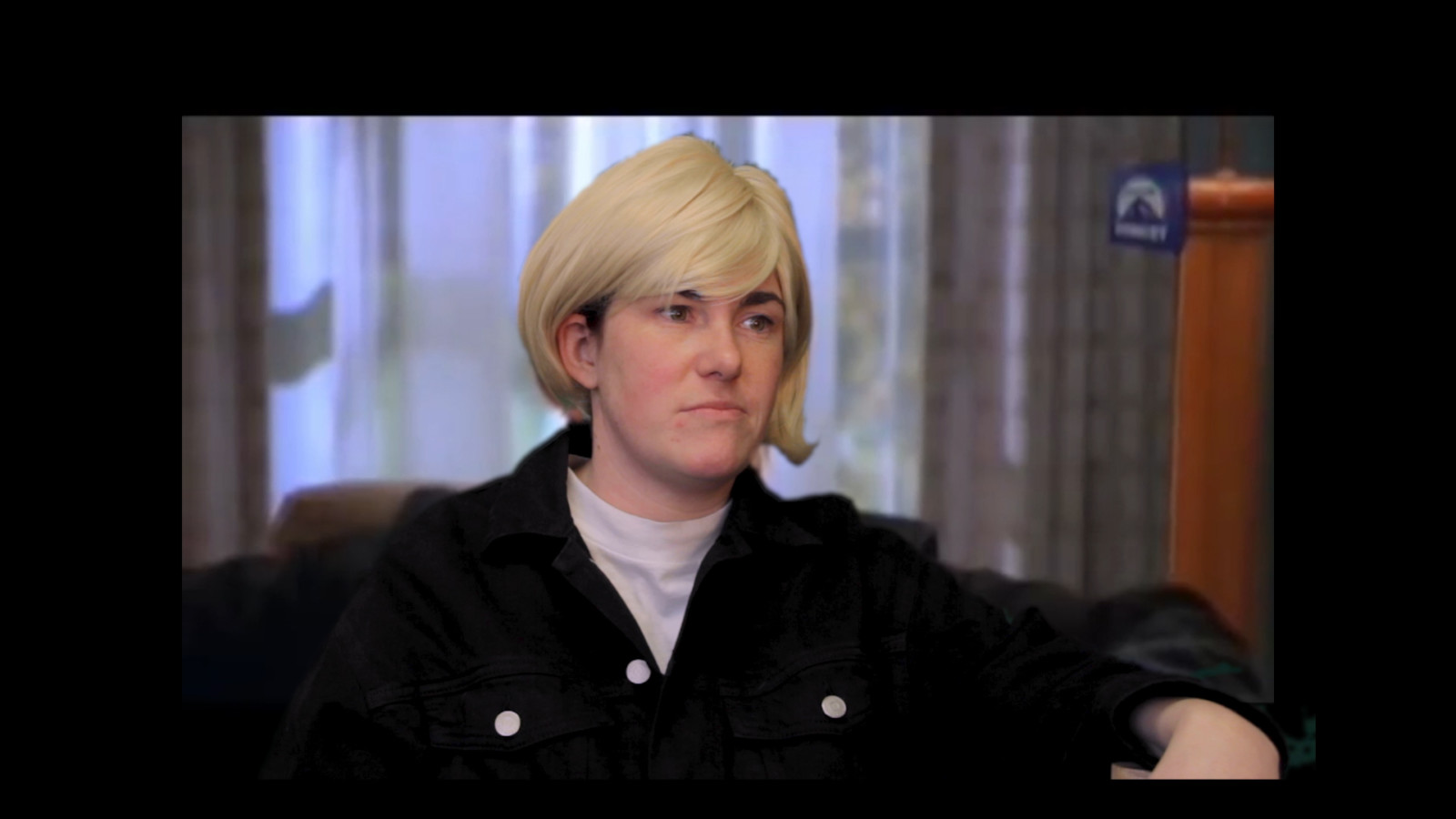 Dressed to look like Ellen Degeneres in that famous episode of Oprah, where Ellen came out. Amy wears a blonde wig a white t-shirt and a black jacket.