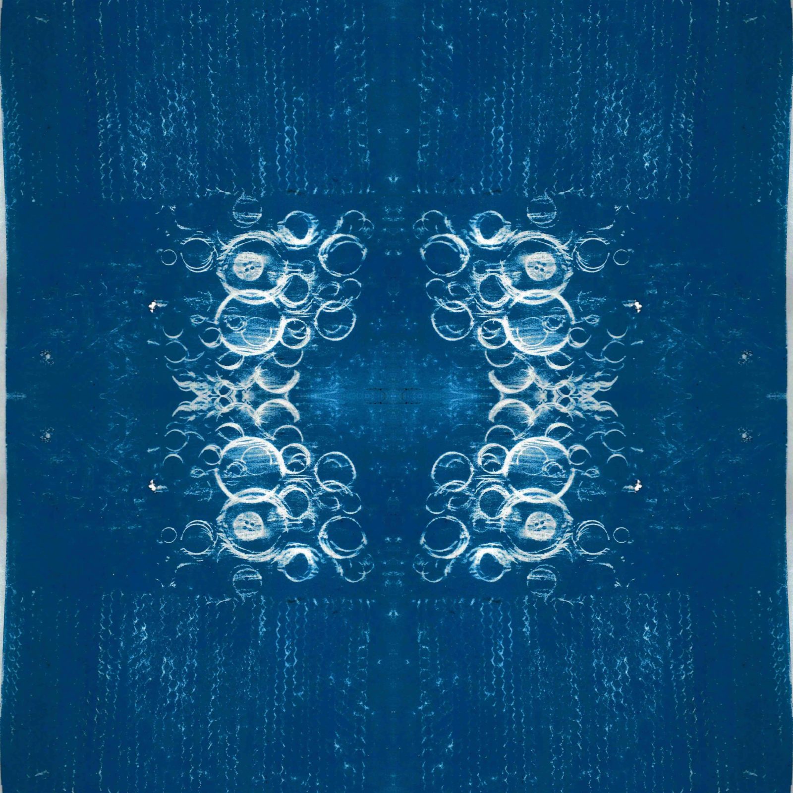 A square blanket decorated with an inky blue design