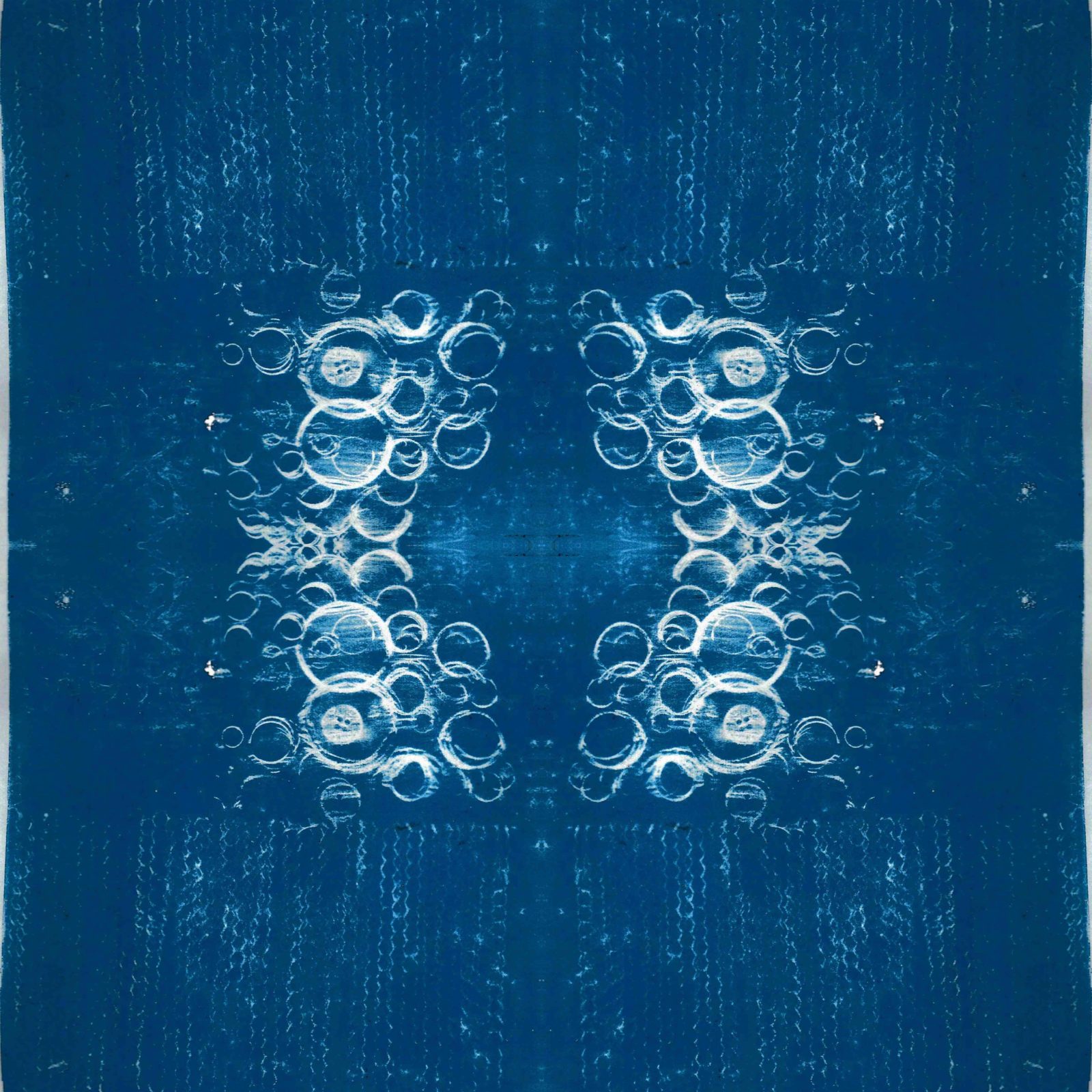 A square blanket decorated with an inky blue design