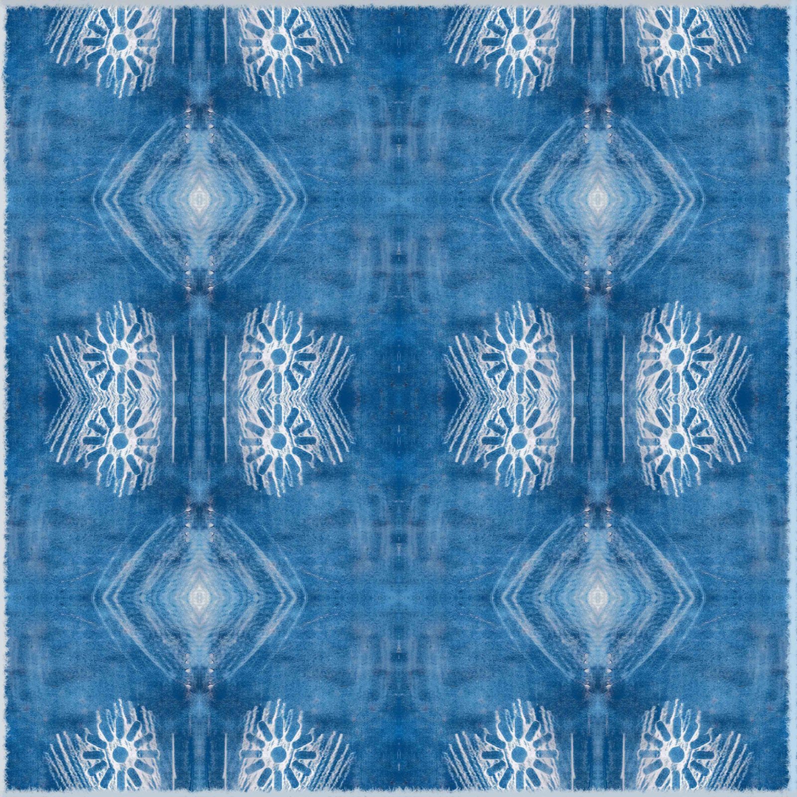 A square blanket decorated with an inky blue design