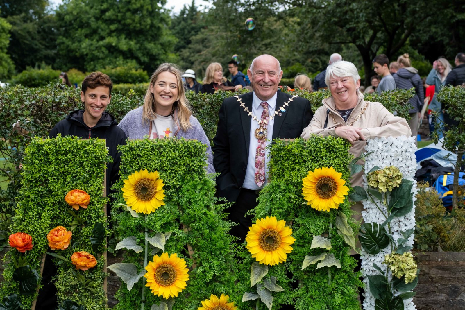 Producer Rhiannon Parry, Artist Leo Soph Welton and the Mayor of Halewood are photographed smiling behind the 'Community' artwork.