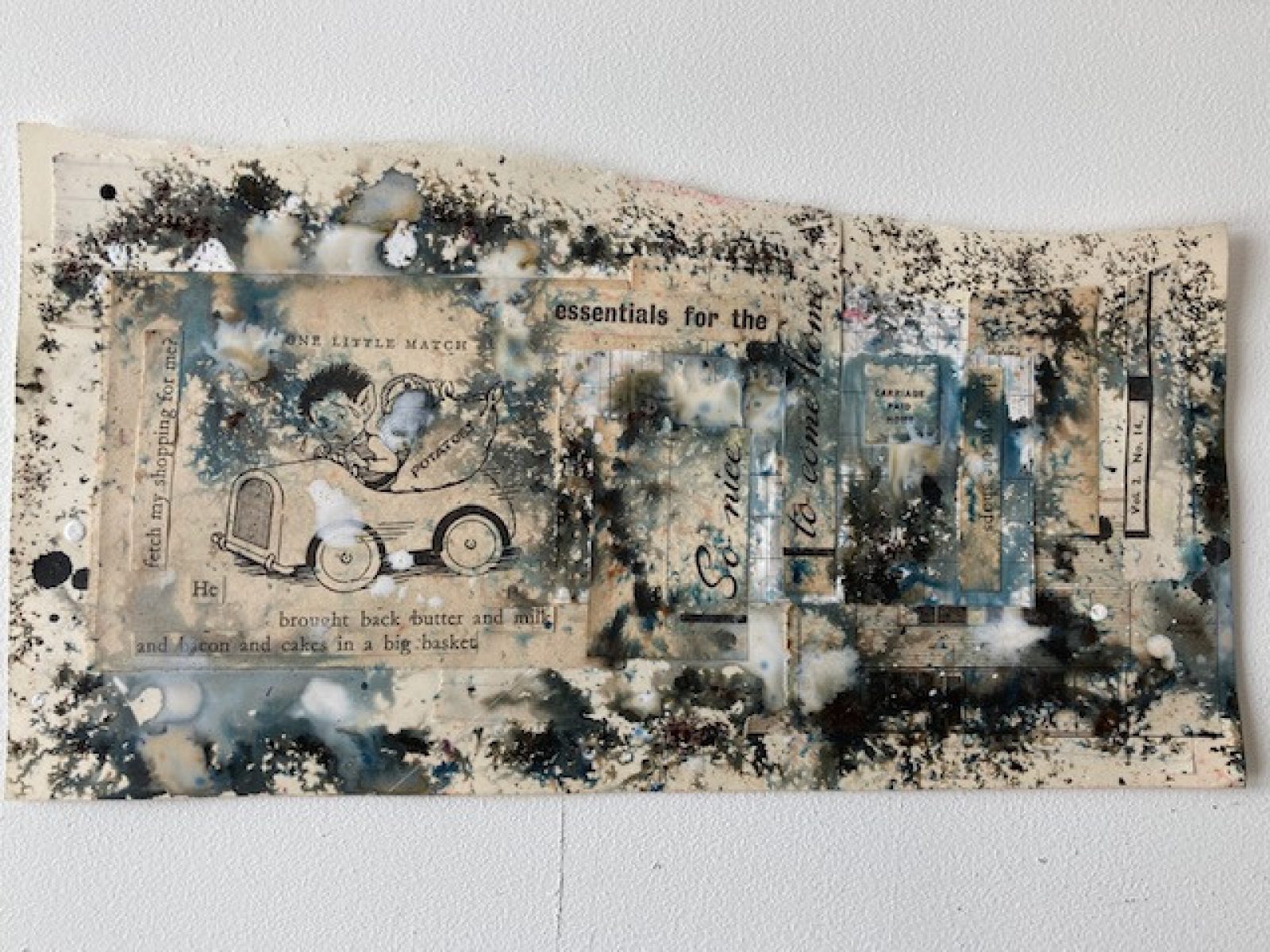 A landscape page is torn through the middle and splashed with ink. On the left is an illustration of a little boy driving an old fashioned car.
