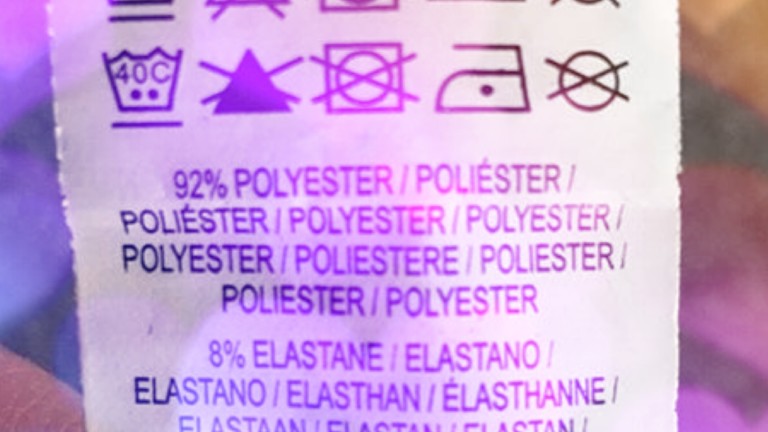Photo os washing instructions on a clothes label with a violet sparkly pattern overlayed on top.