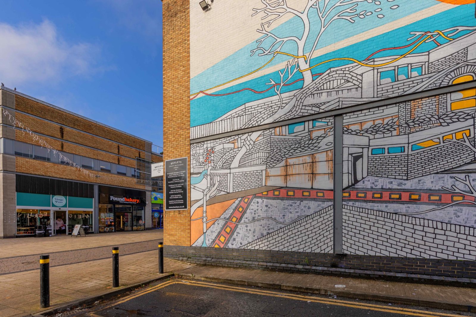 The Welcome Home mural by Jo Peel is photographed on a sunny day on Huyton High Street.