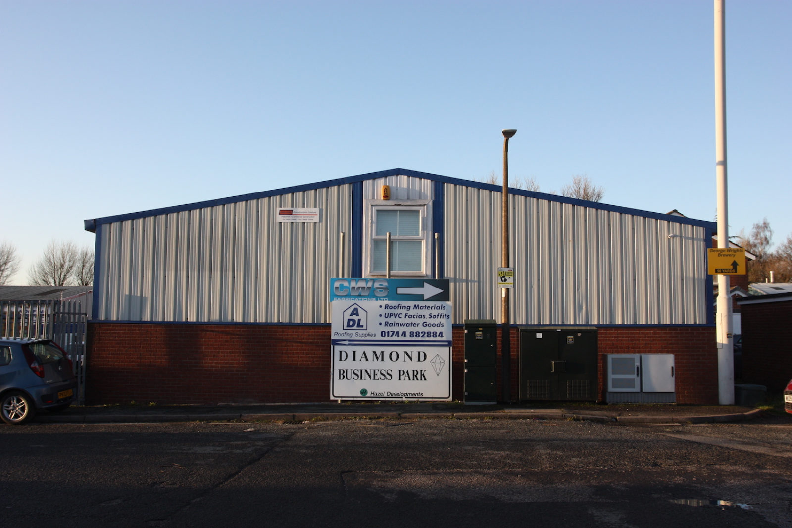 Diamond Business Park sign is in front of a large light grey corrugated metal building.