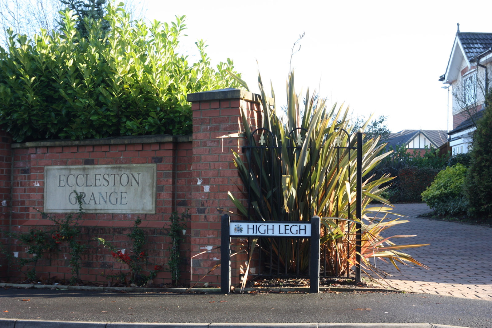 High Leigh Street is in front of a driveway next to a brick wall that reads Eccleston Grange.