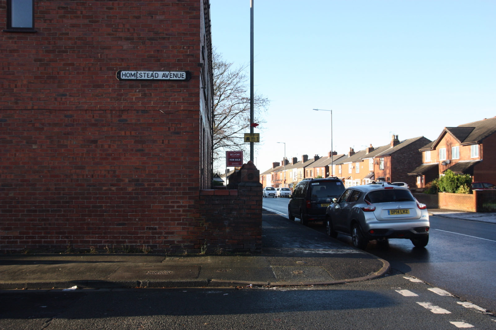 Homestead Avenue Sign is on the side of a red brick house.