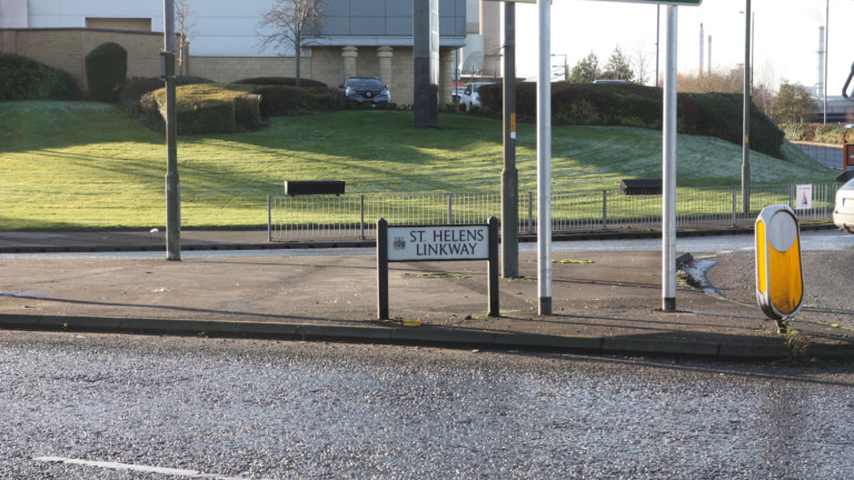 St Helens Linkway sign is on a pavement in between crossroads.