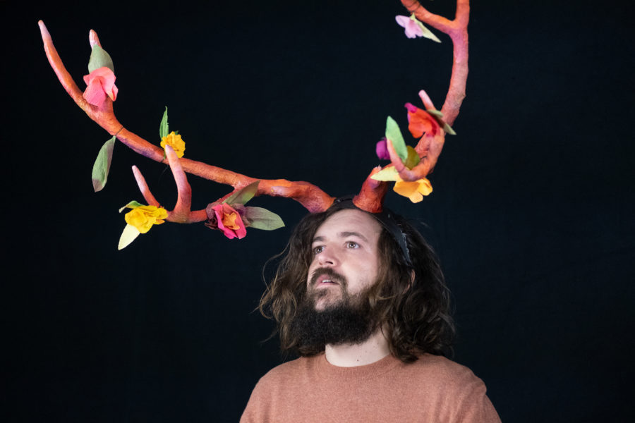 Headshot of Man wearing hand made antlers with flowers on them.