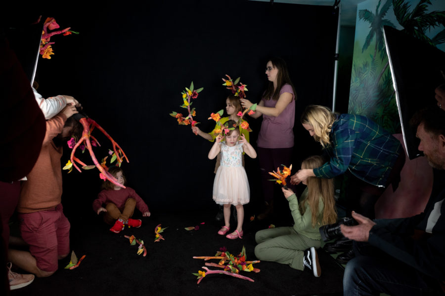 Adults helping kids assemble and wear antlers for workshop.