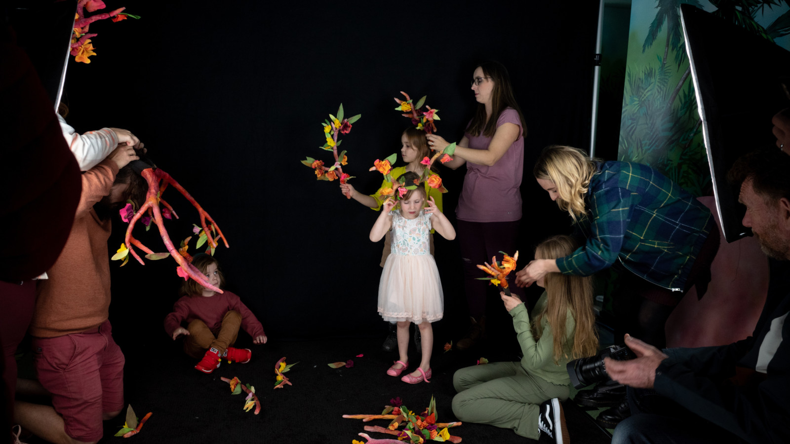 Adults helping kids assemble and wear antlers for workshop.