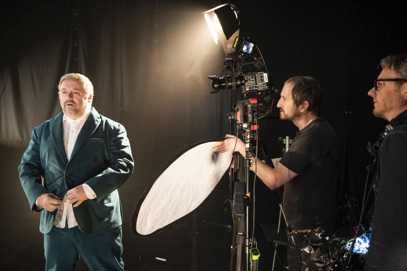 Pete on the Full of Grace set. To the right the stage crew position lighting equipment around Pete.