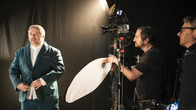 Pete on the Full of Grace set. To the right the stage crew position lighting equipment around Pete.