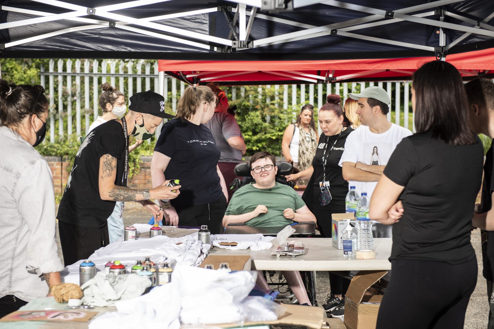 Nomad Clan's Jay Gilleard is pictured spray painting t-shirts with a group of Parr residents.