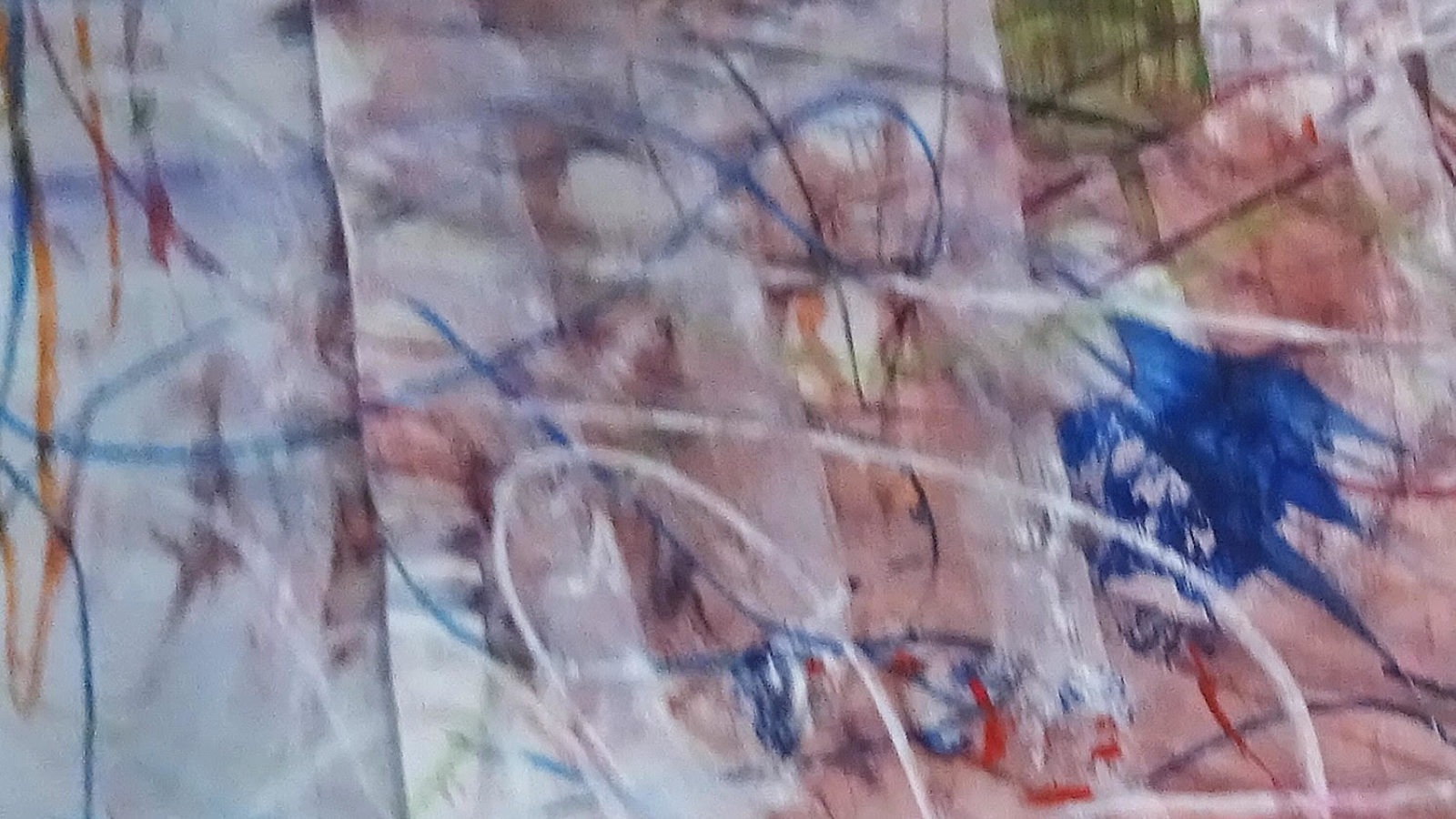 A piece of paper with colourful abstract scribbles all over it.
