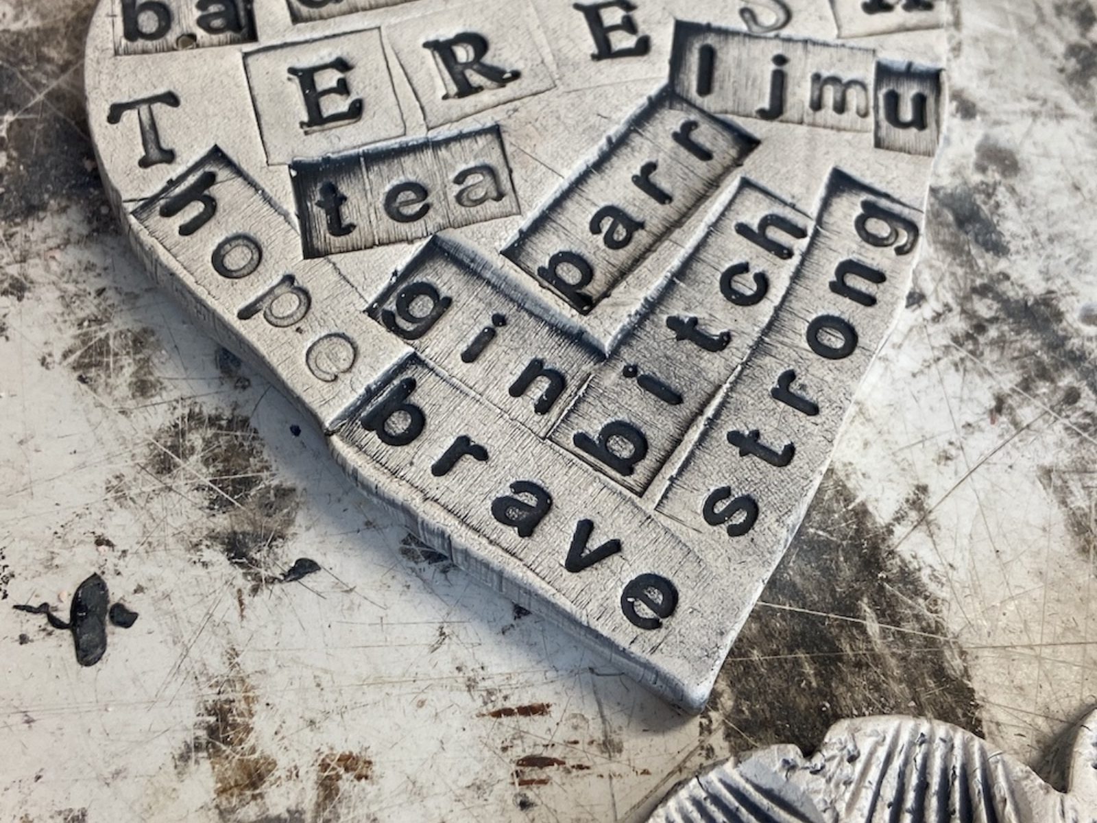 Two clay hearts with tiled letters showing personal messages