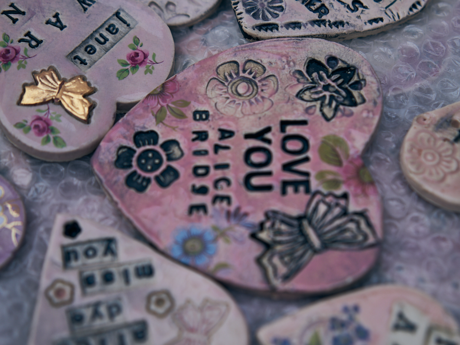 A series of clay hearts with dedications to women