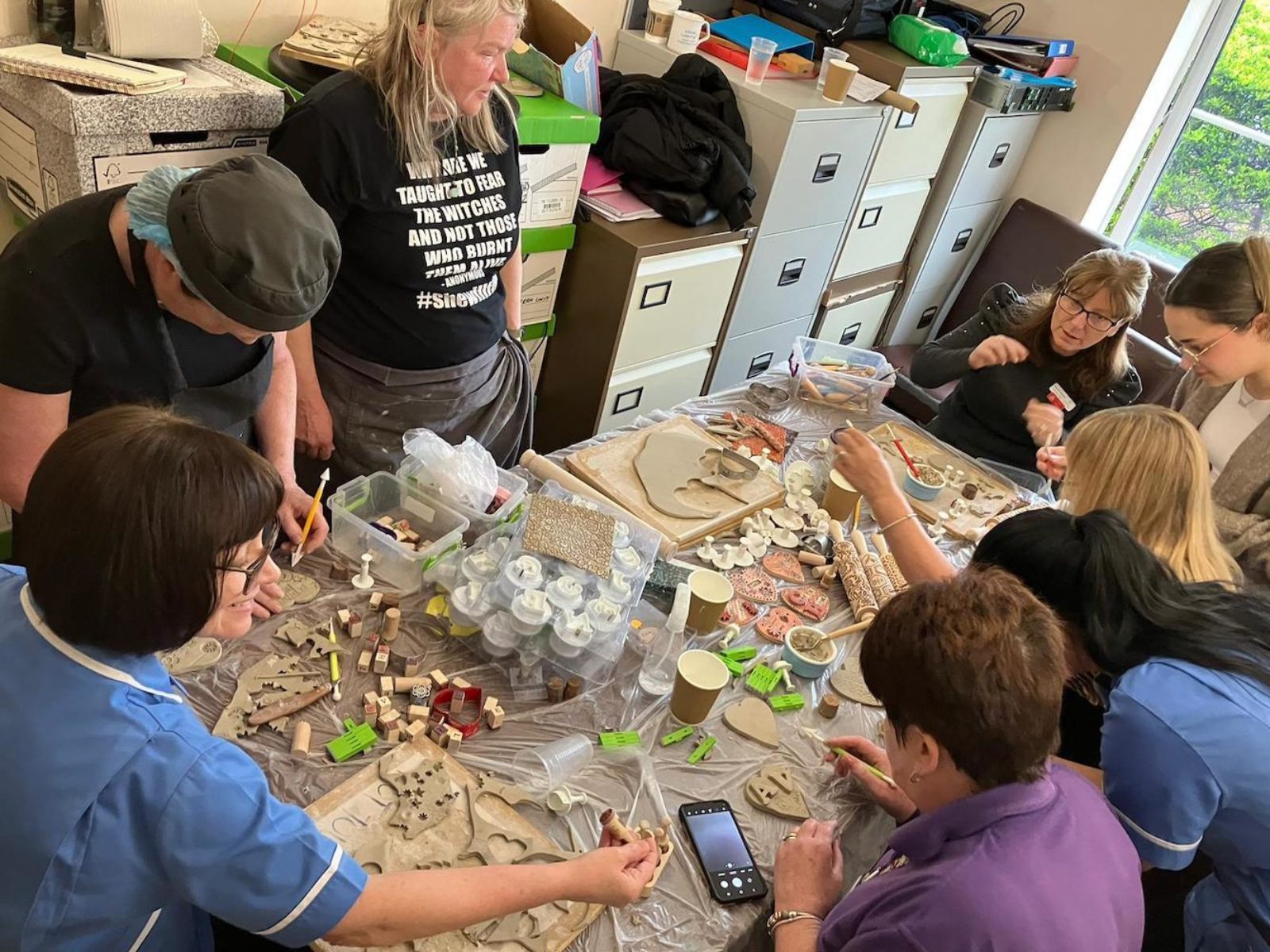 A group of adults around a table sculpting with clay