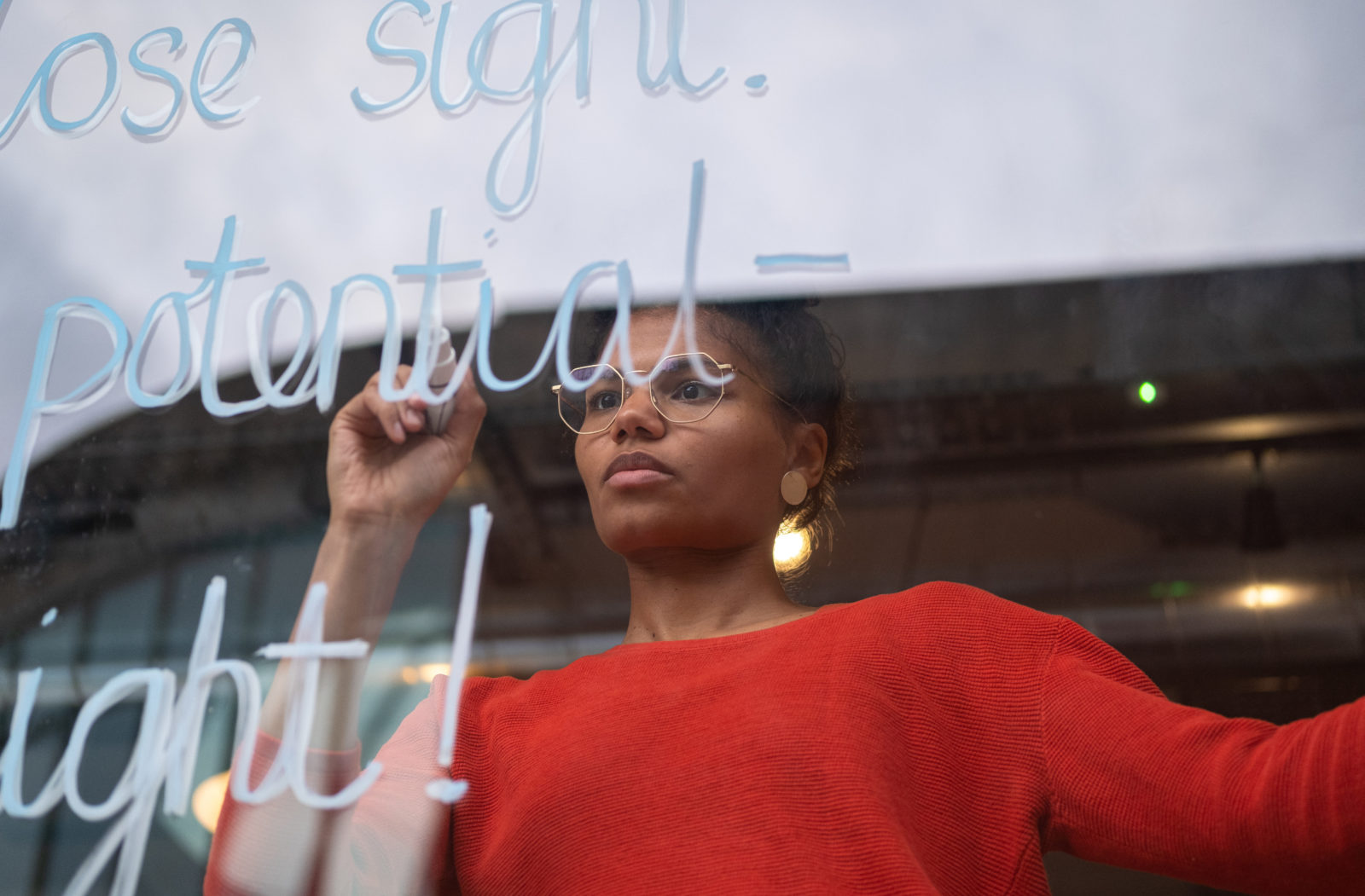 Close up of Ella writing poem on window