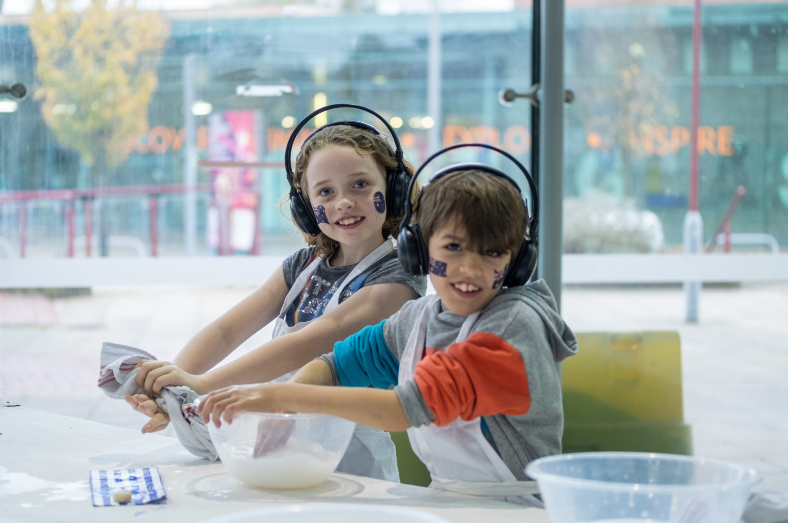 Kids washing hands and smiling at camera