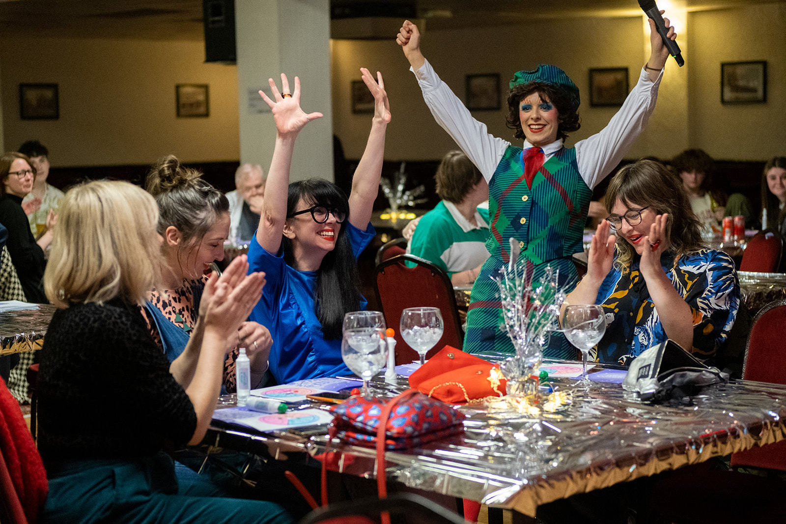 Figs in wigs celebrating with a table in the audience