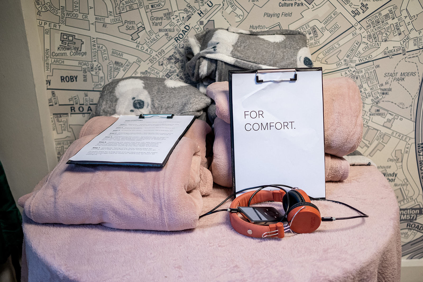Bile of blankets and an MP3 player with headphones, next to a sign saying 'for comfort'
