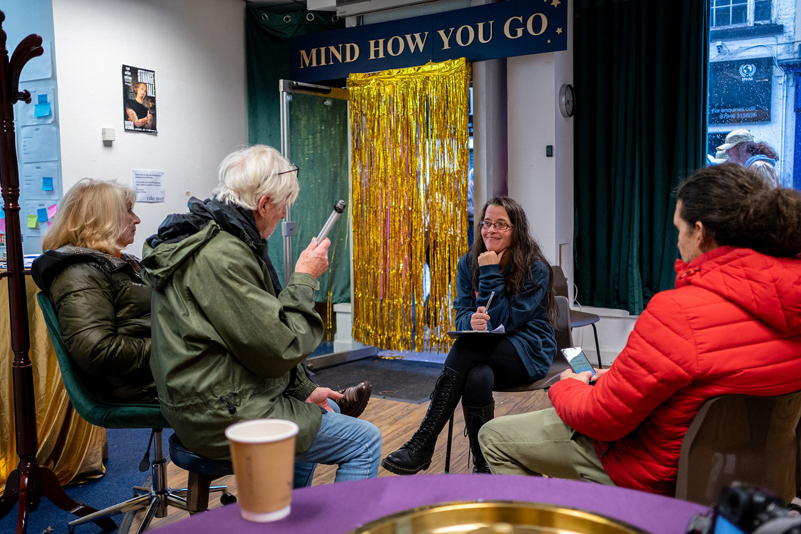 A group of people having a conversation in 'the cloakroom'