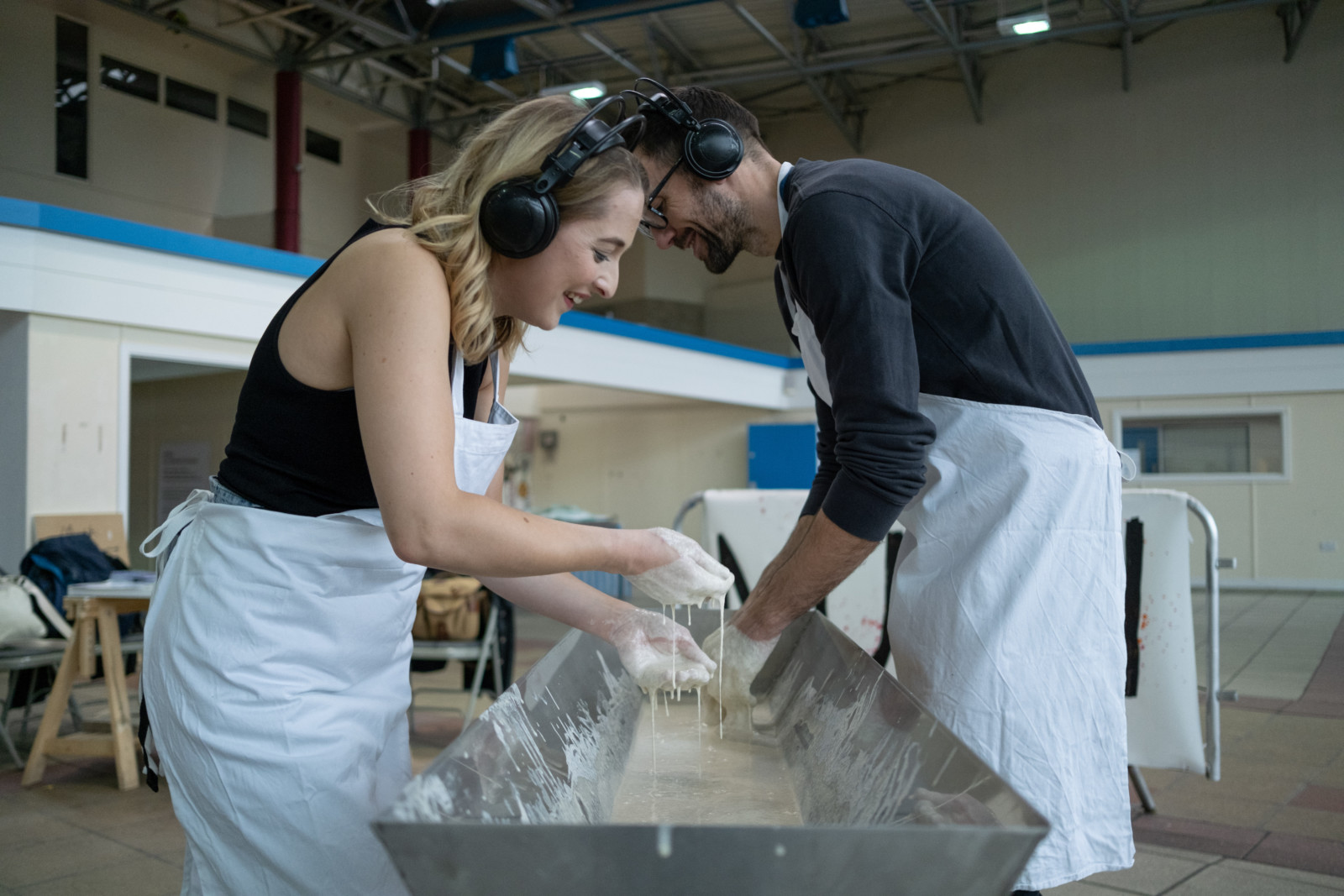 Two people partaking in MUSH, dipping hands in sourdough mother