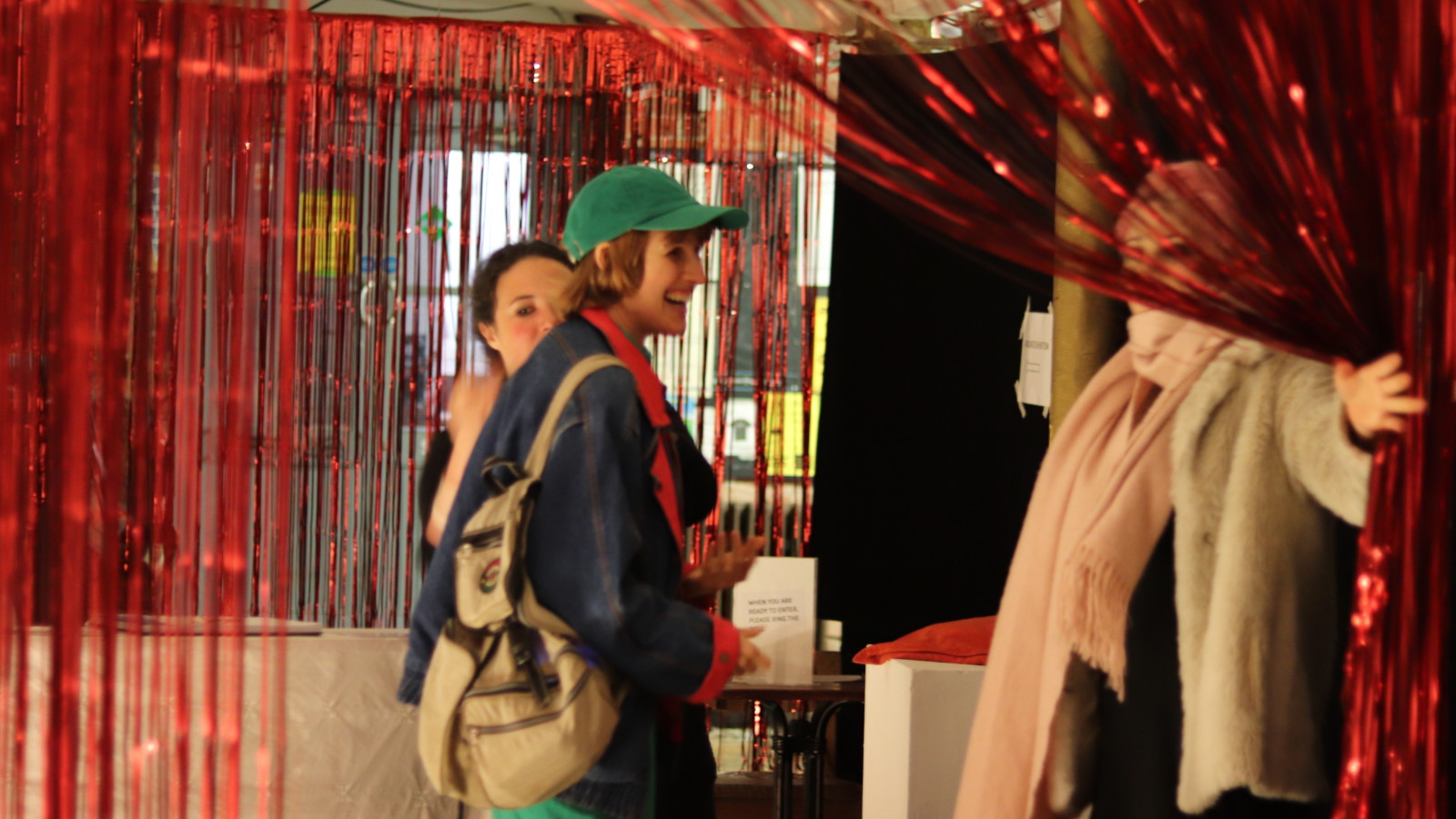 Person being welcomed into the the Cloakroom through tinsel curtain