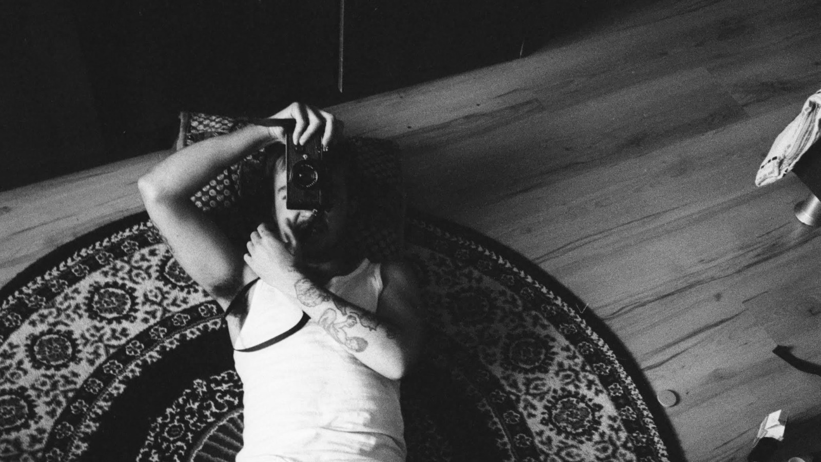The photographer lying on the floor, taking a photograph.