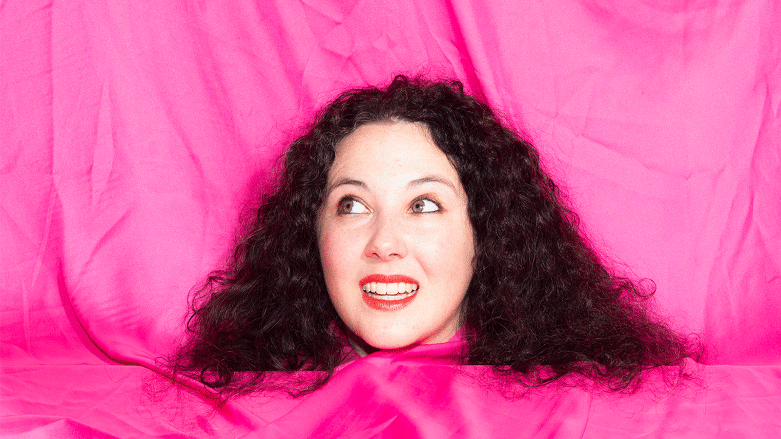 The artist's head appears on a bright pink background