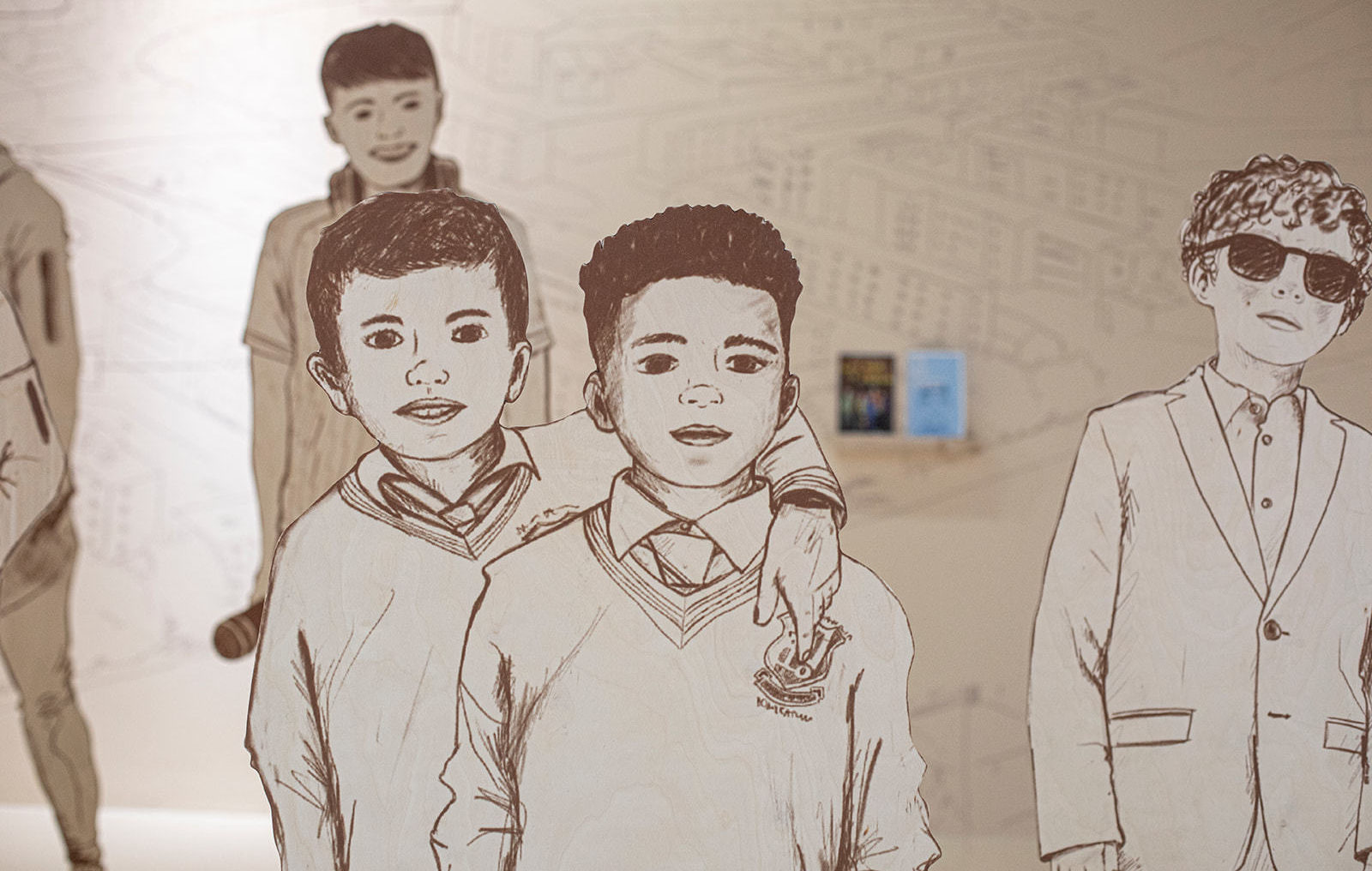 Illustrations of teenage boys printed as large cut outs and arranged in a 3D display with a hand drawn illustrated back drop of the same style.