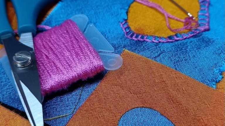 Photograph of sewing scissors, needle and thread