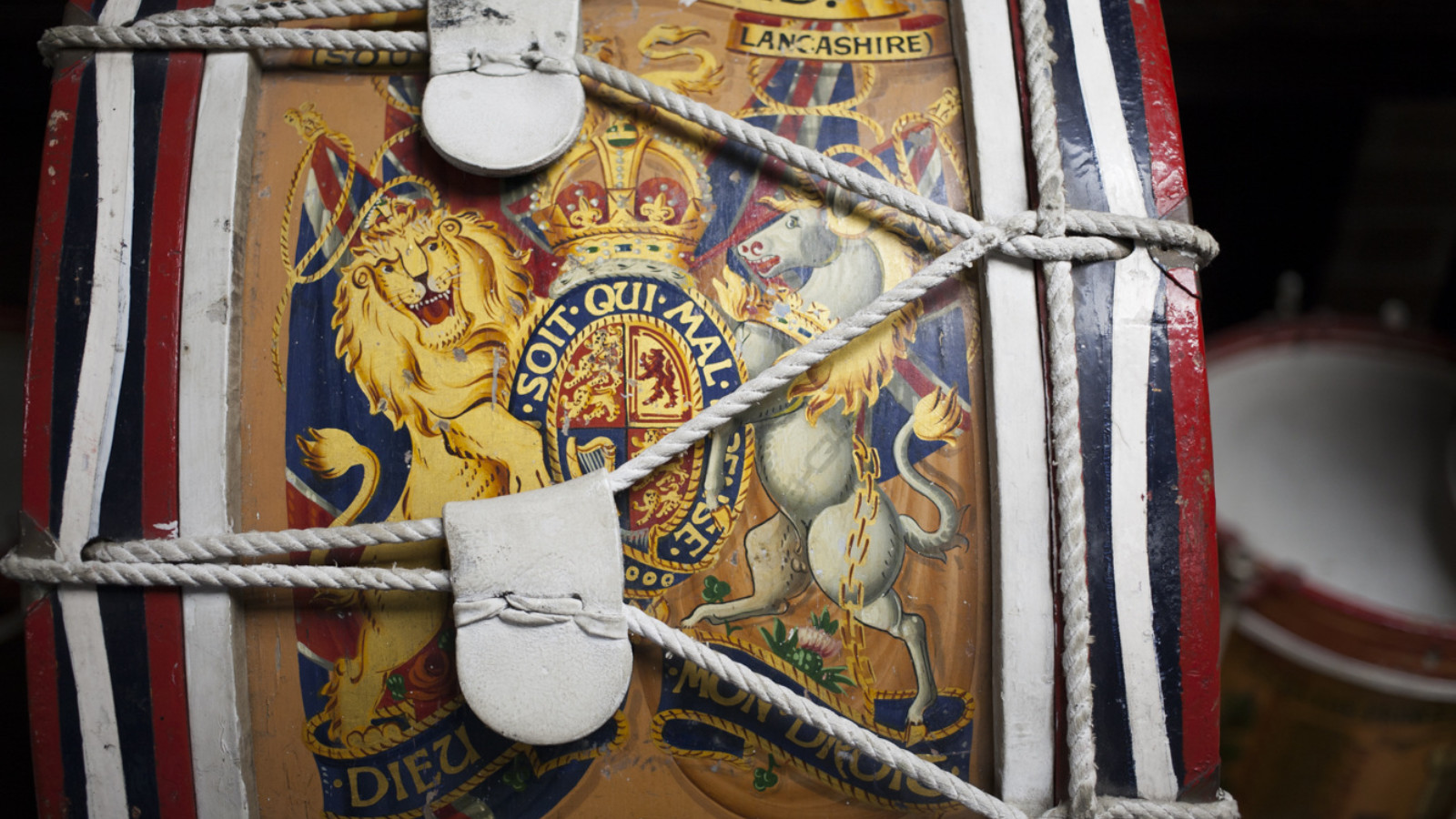 A close up image of a crest with a lion and a horse painted on to wood and wrapped in ropes.