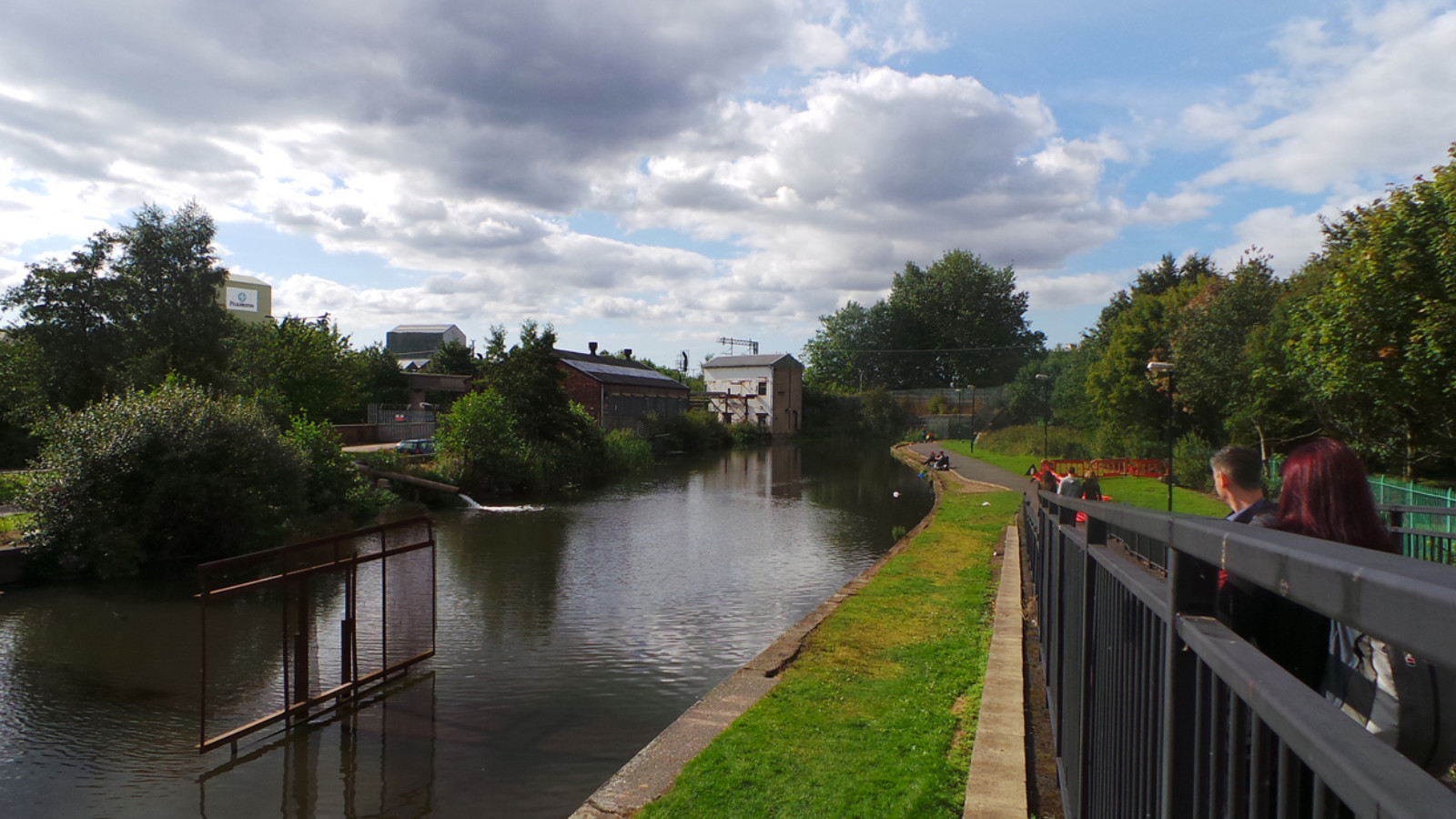 A canal surrounded by grass and trees.