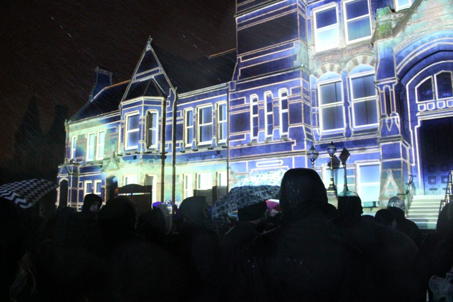 St Helens Town Hall is lit up with a bright white projection against a night sky.
